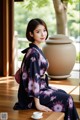 A woman in a kimono sitting on a table with a cup of coffee.